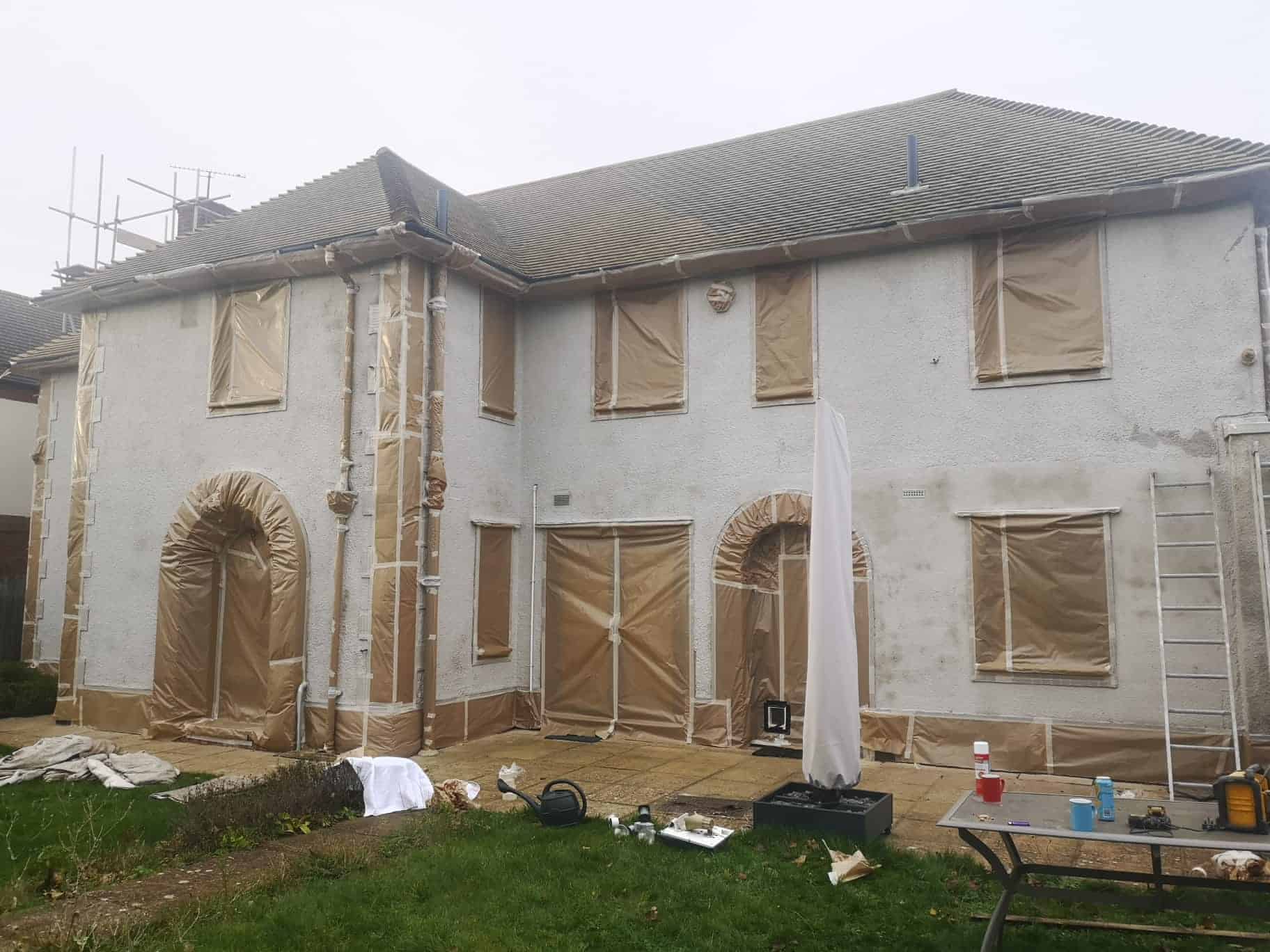 front of house with masking and primer coat onto the render